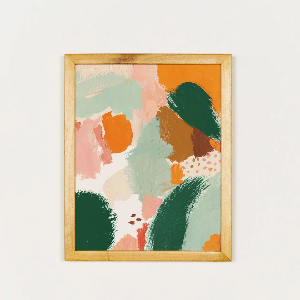 Framed abstract art print with colorful shapes on a white wall
