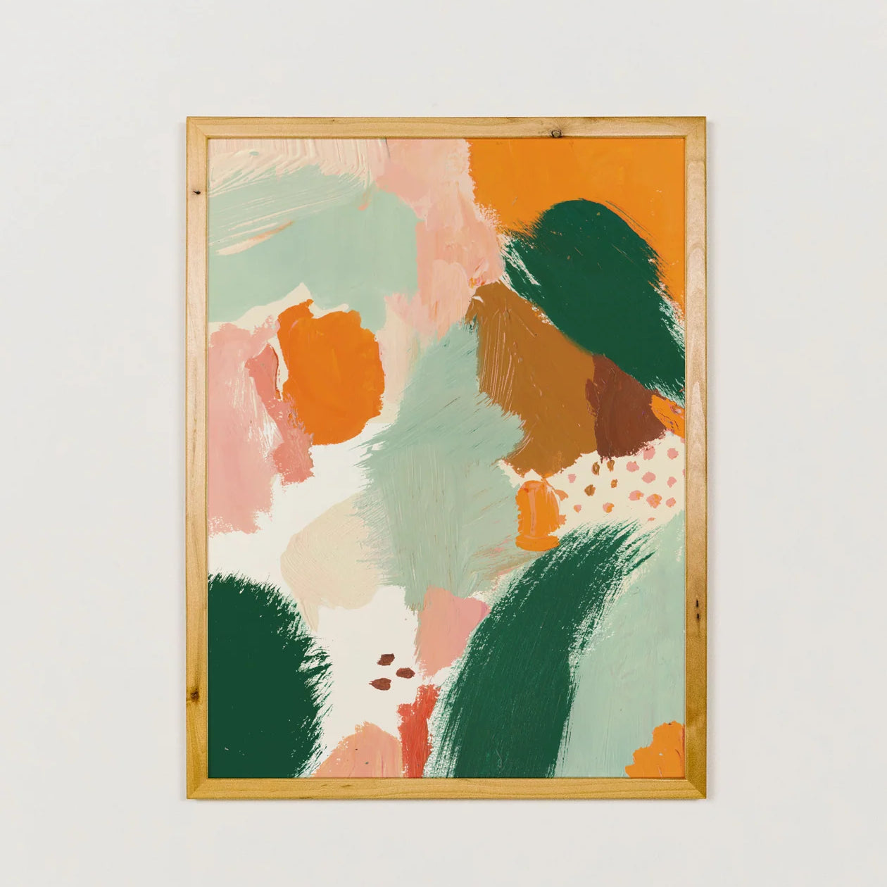 Framed abstract art print with colorful shapes on a white wall