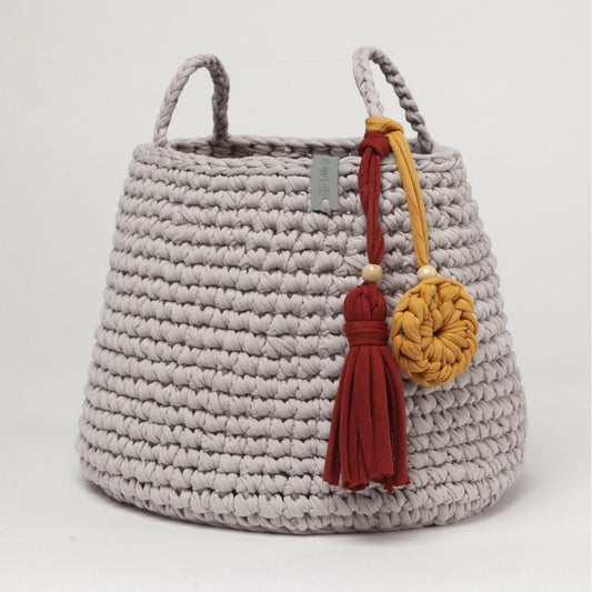 Crocheted basket with tassels on a white background